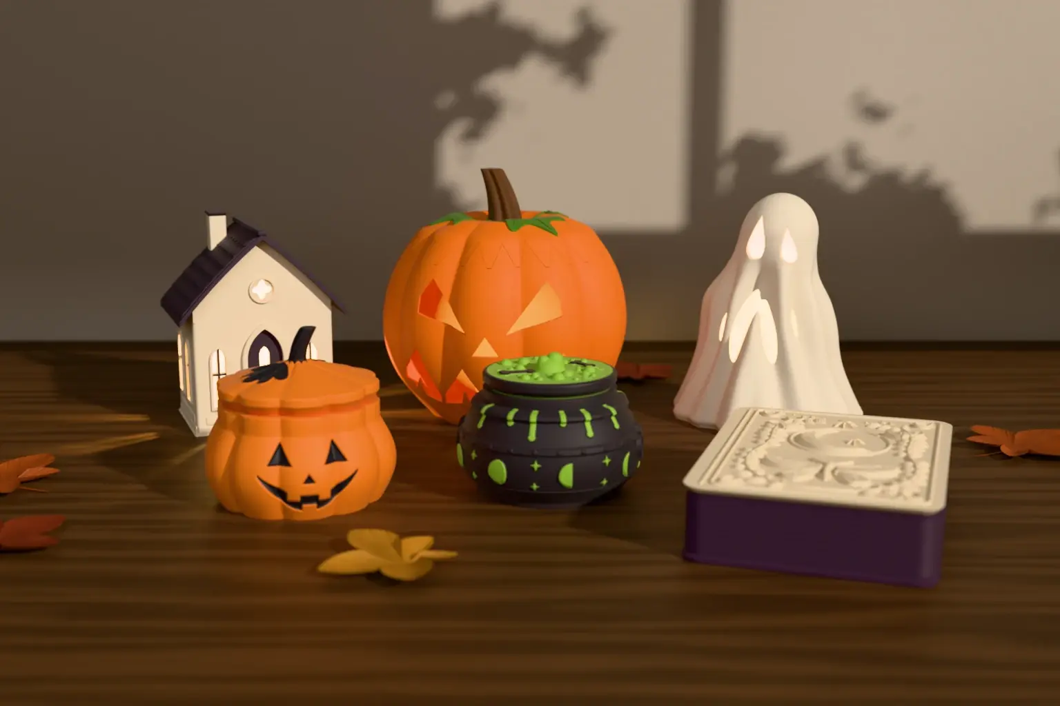 The Halloween collection on a walnut table: an ivory hollow house, an orange carved pumpkin and an ivory draped ghost glowing with battery tea lights, with a jack-o’-lantern box, a bubbling cauldron box and a plum-and-ivory grimoire box in front.